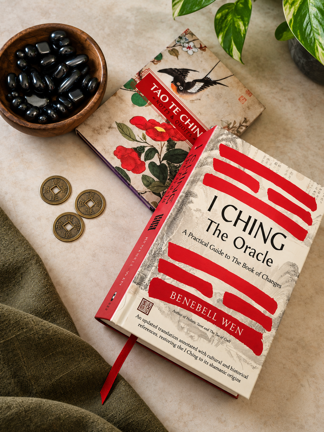 An I-Ching book, a Tao Te Ching notebook, divination coins, and a bowl of polished black stones.